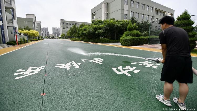 Chino con manguera tira agua sobre un asfalto permeable al agua