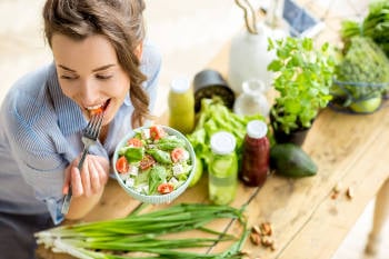 Una mujer comiendo ensalada