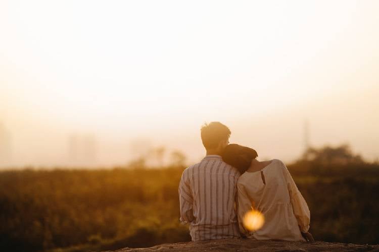 Pareja campo sol Una mujer se apoya sobre el hombro de su pareja