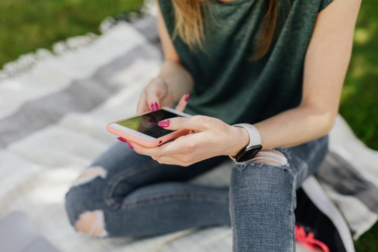 Mujer sosteniendo un teléfono en sus manos