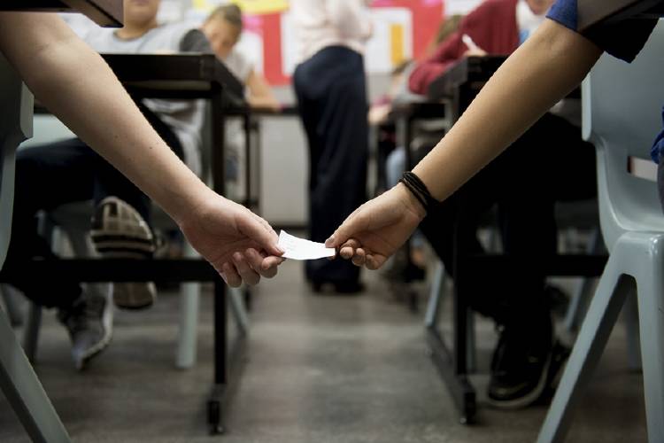 estudiantes haciendo trampa en examen