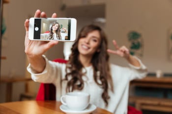 portrait of cheerful woman taking selfie