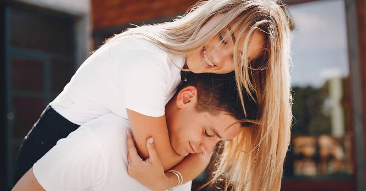 calcular-exito-relacion-amorosa pareja heterosexual abrazandose al aire libre