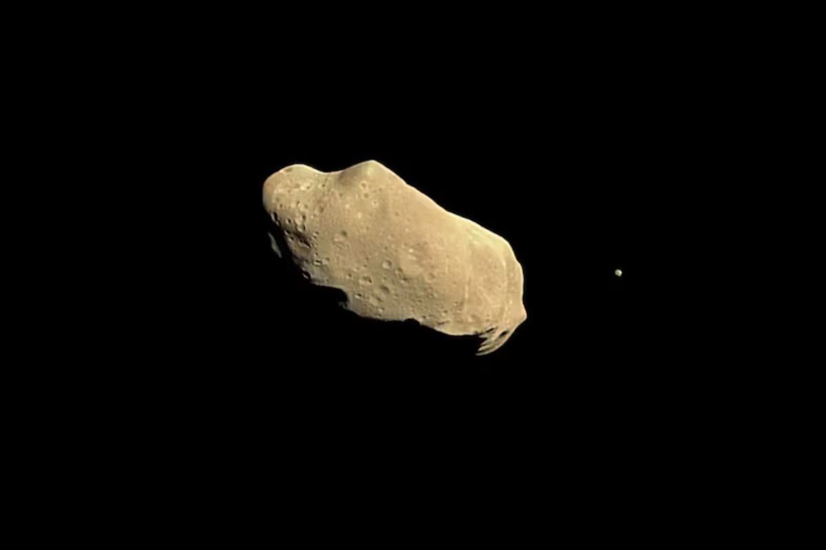 Imagen gráfica de un asteroide; la luna es visible a la derecha del objeto. (NASA/JPL)