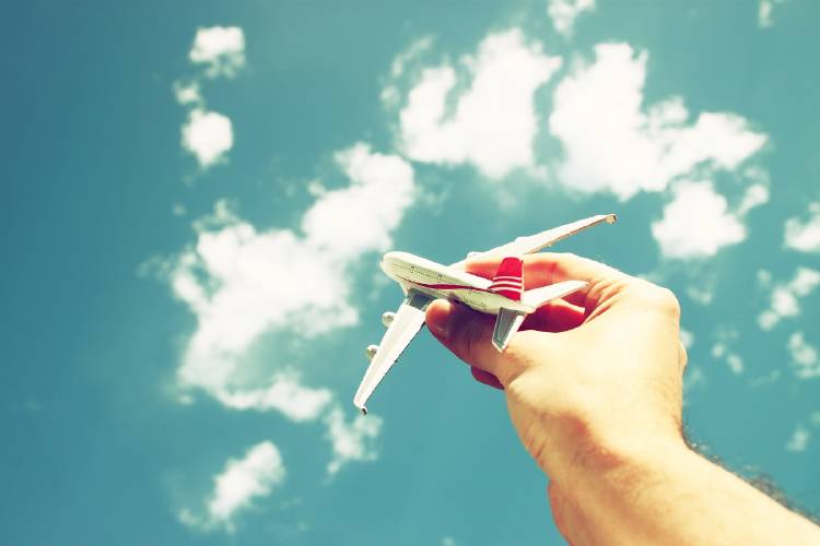 Avión de juguete sobre cielo con nubes