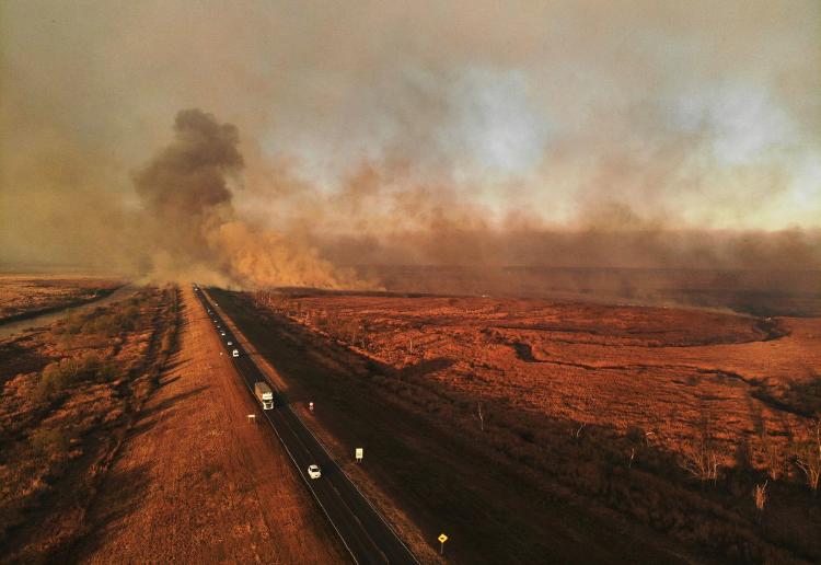 Autos que circulan entre el humo por la quema de pastizales en el Delta del Paraná. Foto: AFP