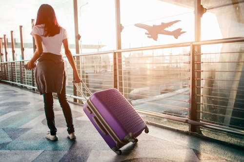 mujer con su maleta espera en el aeropuerto 