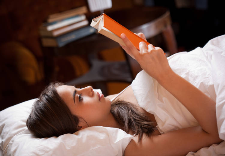 Una mujer leyendo en la cama