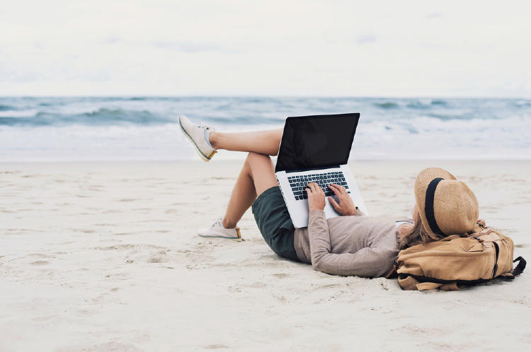 mujer computadora en la playa