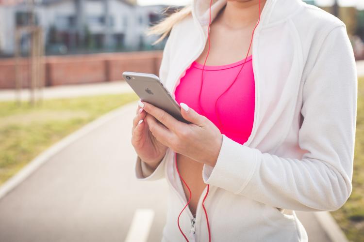 mujer deportista escuchando musica utsando telefono movil