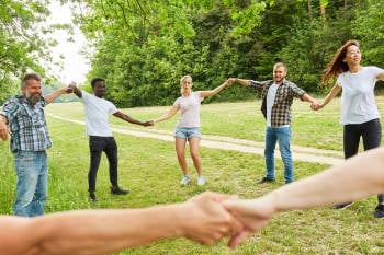 grupo de amigos baila en ronda al aire libre