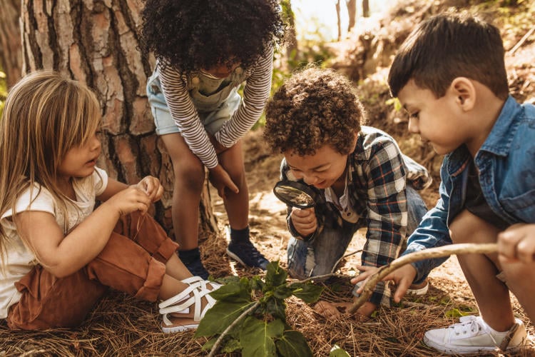 Niños mirando a través de una lupa