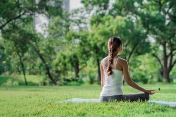 Mujer practicando yoga en un parque de su ciudad