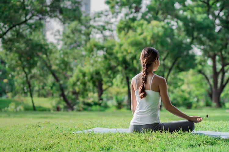 Mujer practicando yoga en un parque de su ciudad