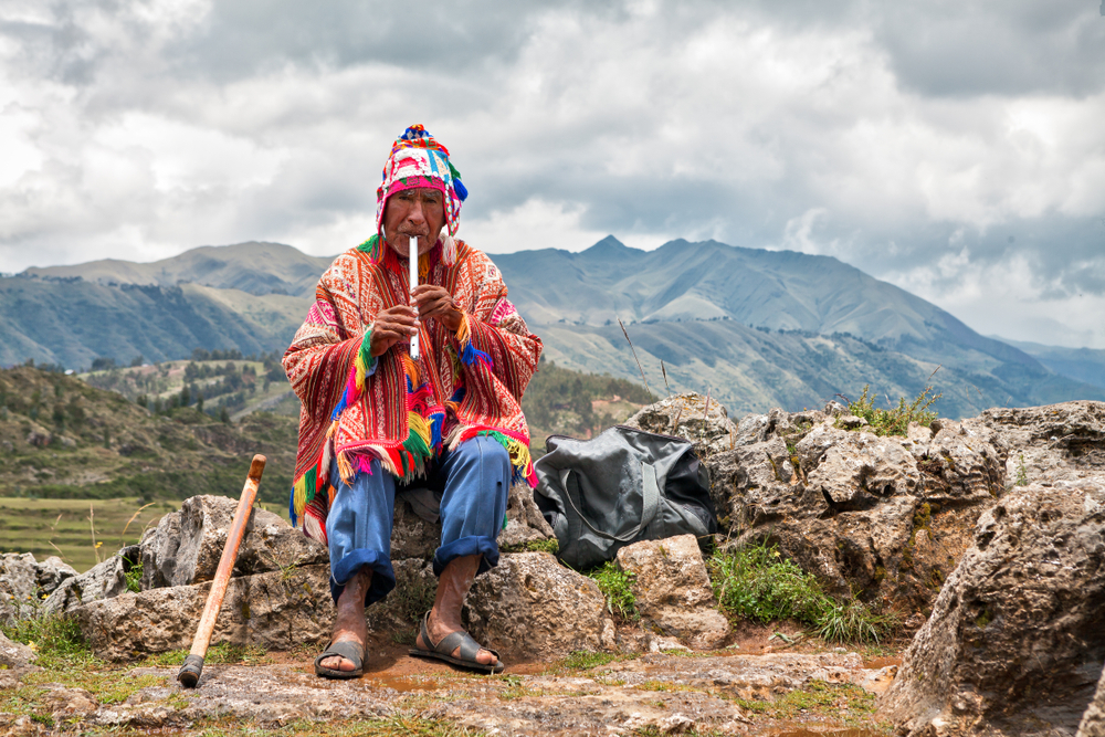 viejo sabio chaman toca un instrumento tipico en las zonas sagradas de cusco, peru