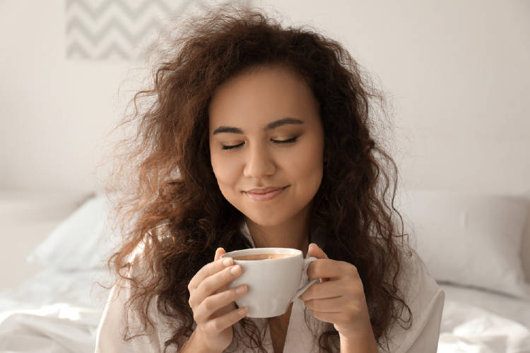 Una mujer bebe café por la mañana