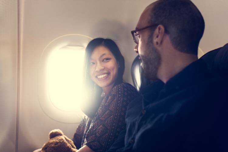 Dos pasajeros conversando en un avión