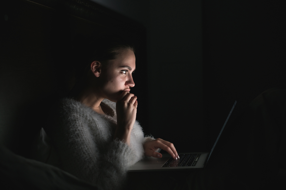 Una mujer mira la computadora de noche