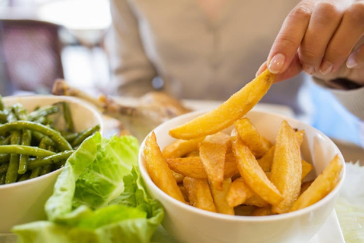 Un persona comiendo papas fritas