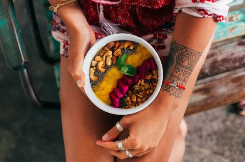 mujer bowl frutas Una mujer con un bowl con frutas y frutos secos