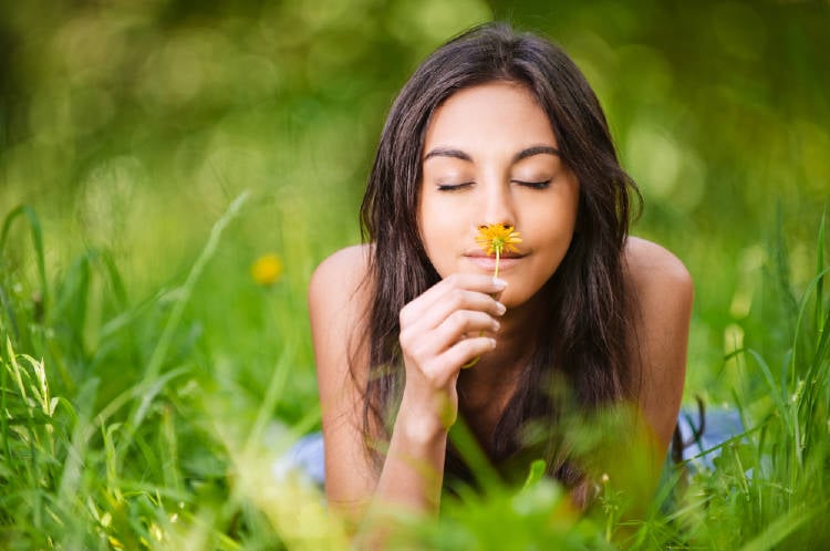 mujer huele flor