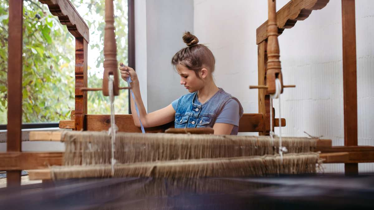 Woman creating a rug using fibrous materials (Representative Image Source: Getty Images | Halfpoint Images)