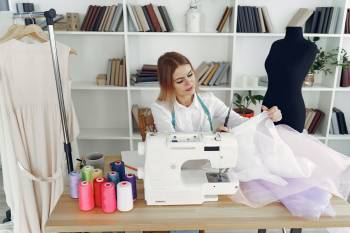 woman in white blouse sitting on chair in front of sewing 3984847