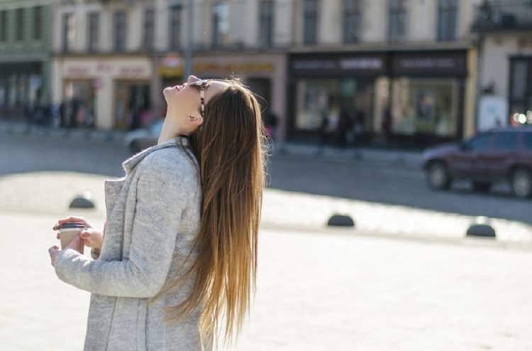 mujer con cabello liso mujer con cabello liso en plaza con café en la mano