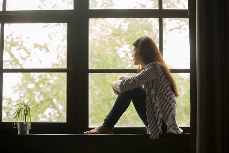 Mujer pensativa mira por la ventana