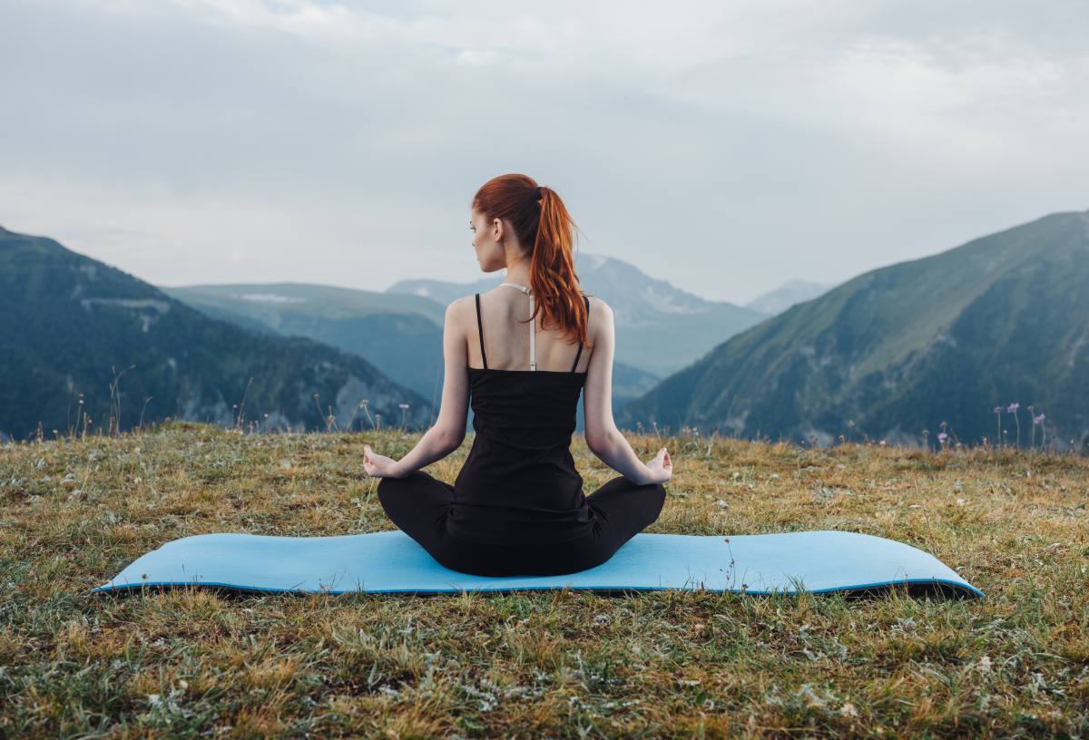 mujer meditando fondo montañas