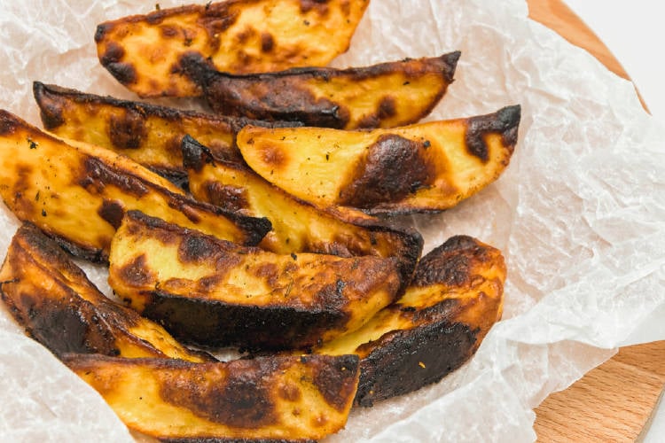 patatas fritas quemadas Patatas quemadas sobre una tabla de madera