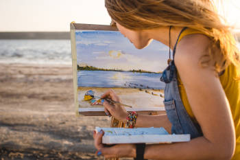 pintura joven pinta un cuadro en la playa