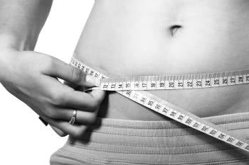 Una mujer mide su abdomen