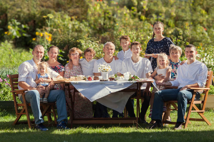 Familia Familia sentada a la mesa en el jardín.
