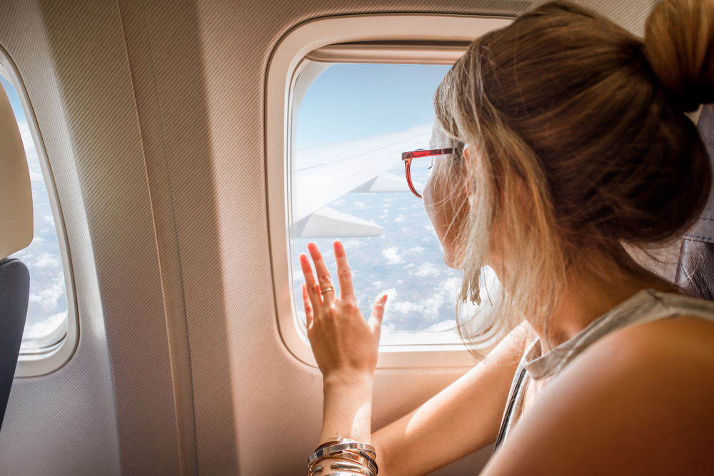 Una mujer mira por la ventanilla de un avión