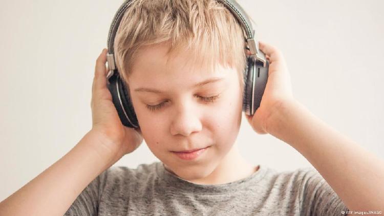 niño escuchando música con auriculares niño escuchando música con auriculares