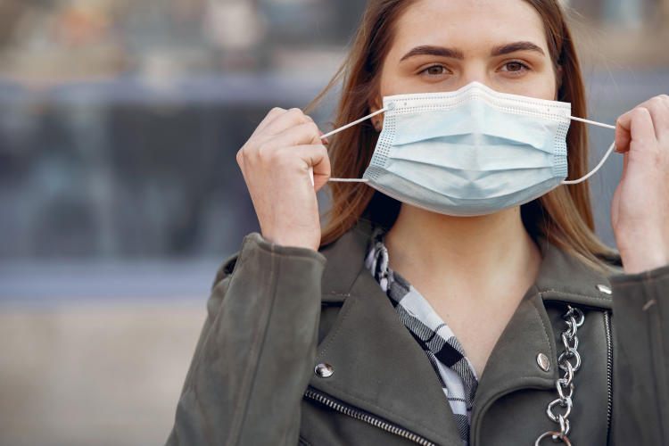 woman in mask stands on the street