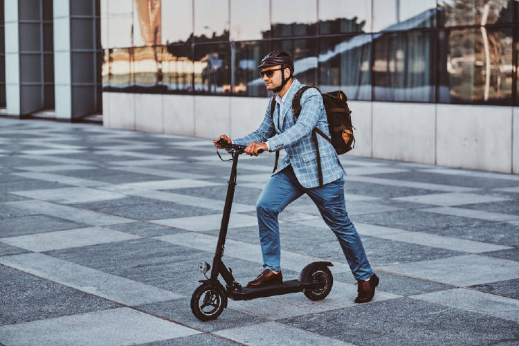 hombre con casco utiliza monopatin electrico