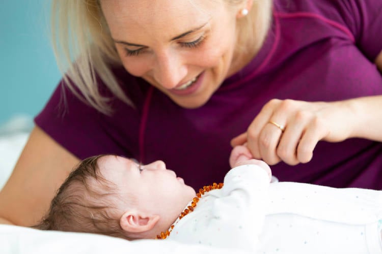 madre bebe Una madre con su bebé que lleva un collar de ambar