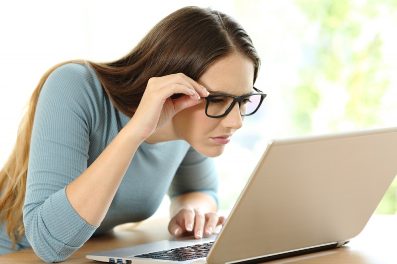 Una mujer con anteojos frente a una computadora