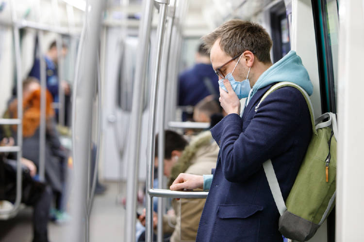 hombre en el subte con barbijo para evitar contagio