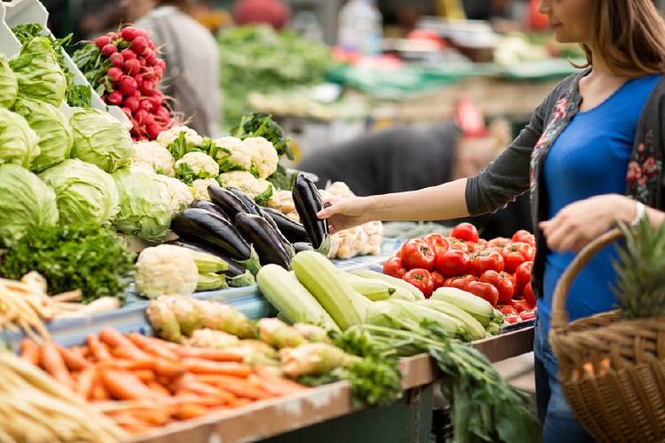 mujer comprando vegetales en el mercado