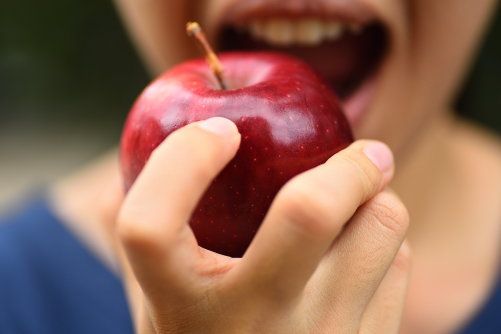 Una mujer comiendo una manzana