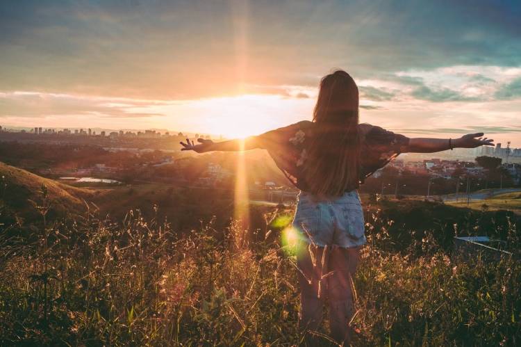 mujer paisaje ciudad Una mujer con los brazos abiertos ante el paisaje de una ciudad