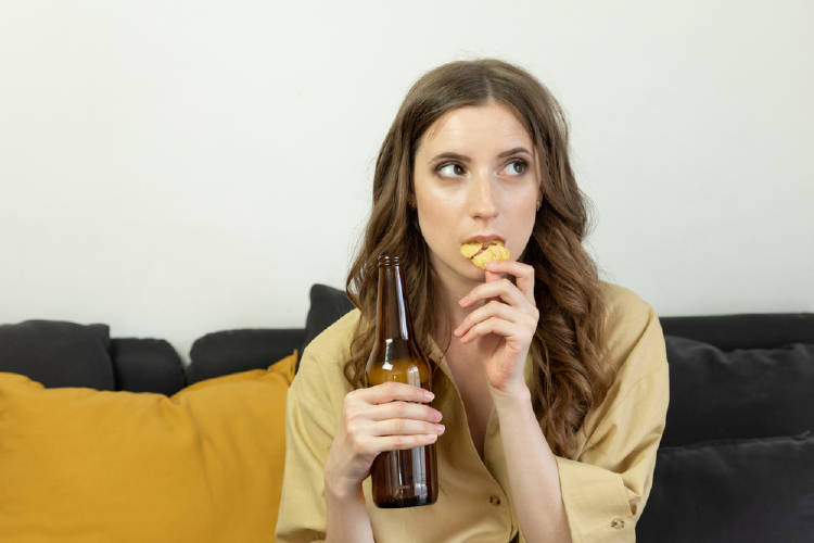 mujer toma cerveza y come papas mujer toma cerveza y come papas