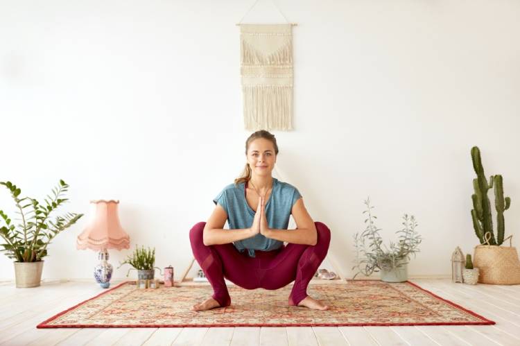 Postura de yoga Malasana Una mujer practicando yoga en la postura Malasana