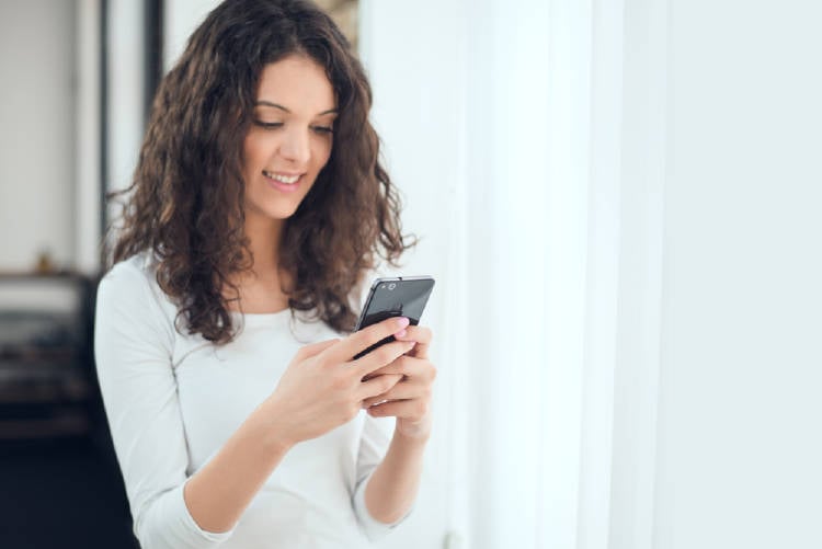 celular mujer sonriente escribe en su celular