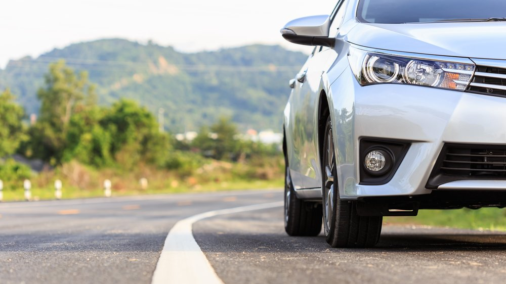 auto de frente sobre la carretera de asfalto, a lado de la línea que divides lo canales y de fondo una montaña y vegetación auto de frente sobre la carretera de asfalto, a lado de la línea que divides lo canales y de fondo una montaña y vegetación.jpg