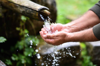 Un hombre moja sus manos en agua potable