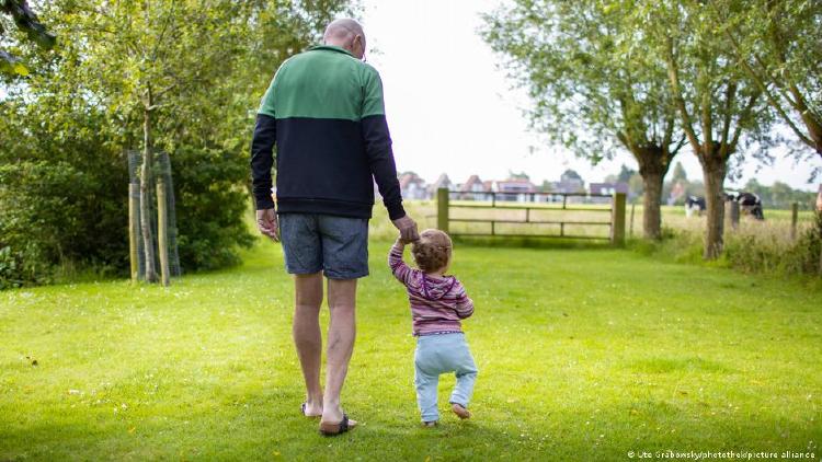 Abuelo caminando de la mano con un niño pequeño